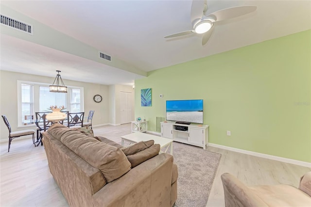 living room featuring light hardwood / wood-style floors and ceiling fan