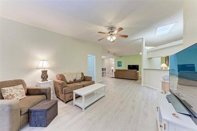 living room with lofted ceiling, ceiling fan, and light hardwood / wood-style flooring