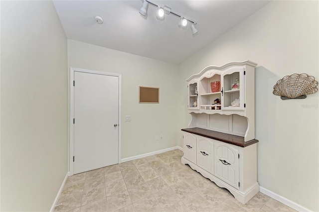 interior space with light tile patterned floors and track lighting