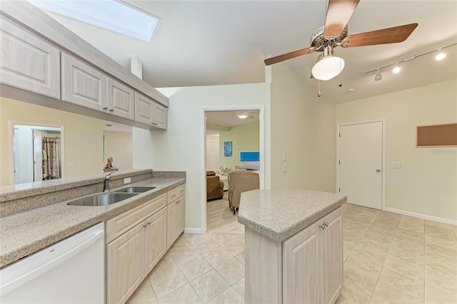 kitchen featuring sink, light tile patterned floors, white dishwasher, ceiling fan, and vaulted ceiling with skylight