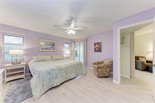 bedroom featuring multiple windows, light hardwood / wood-style floors, and ceiling fan