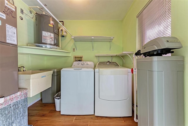 washroom with separate washer and dryer, sink, and light hardwood / wood-style flooring