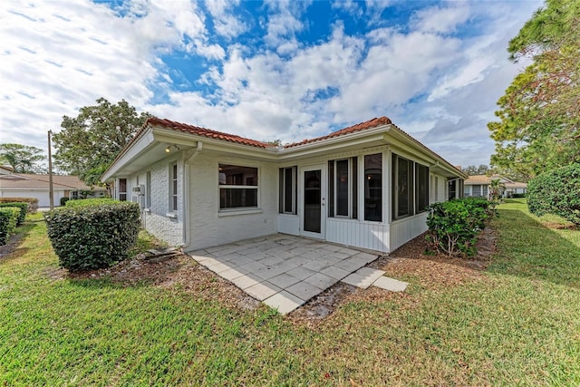 back of house with a lawn and a patio area