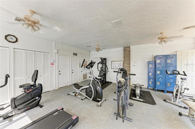 workout area featuring ceiling fan and a textured ceiling