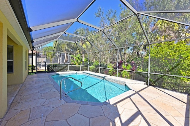 outdoor pool with glass enclosure and a patio area