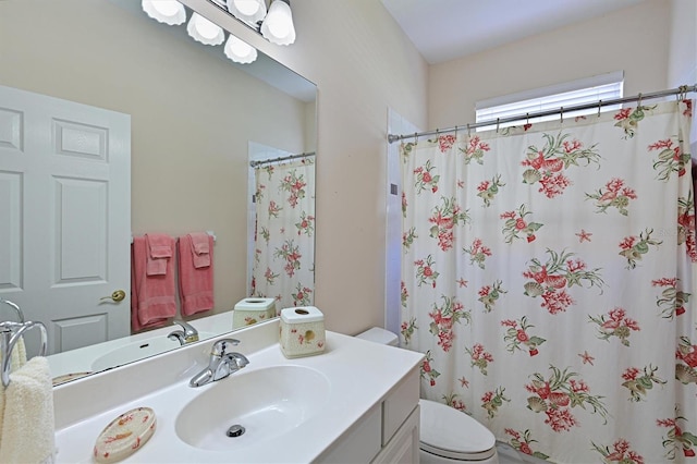 bathroom with vanity, curtained shower, and toilet