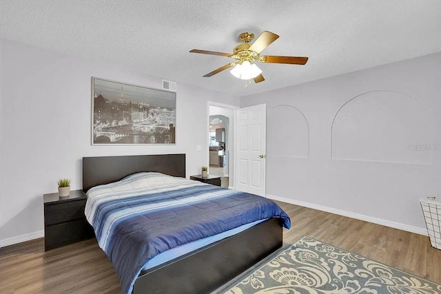 bedroom with hardwood / wood-style floors, a textured ceiling, and ceiling fan