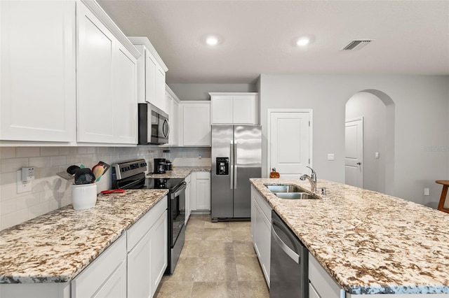 kitchen with sink, white cabinetry, tasteful backsplash, a center island with sink, and appliances with stainless steel finishes