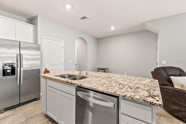 kitchen with stainless steel appliances, sink, a center island with sink, and white cabinets