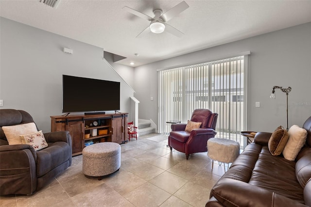 living room featuring light tile patterned floors, a textured ceiling, and ceiling fan