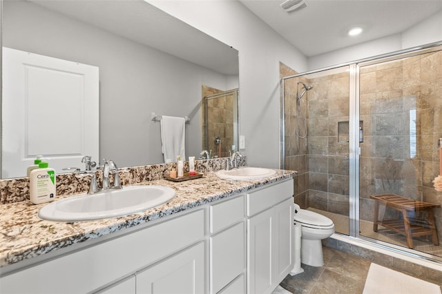 bathroom featuring vanity, toilet, and a shower with door