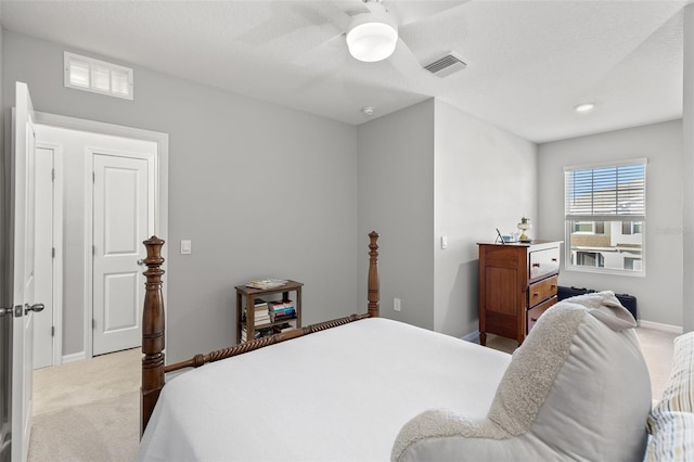 carpeted bedroom with ceiling fan and a textured ceiling