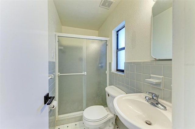 bathroom featuring sink, tile walls, an enclosed shower, and toilet