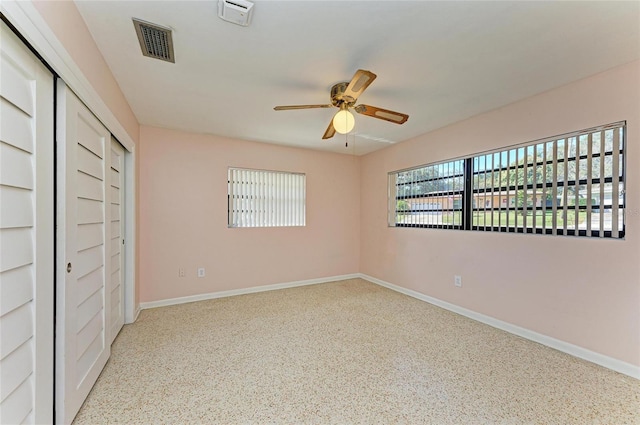 unfurnished bedroom with ceiling fan and a closet