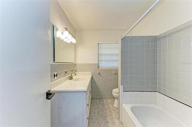 full bathroom with vanity, tile walls, toilet, and washtub / shower combination