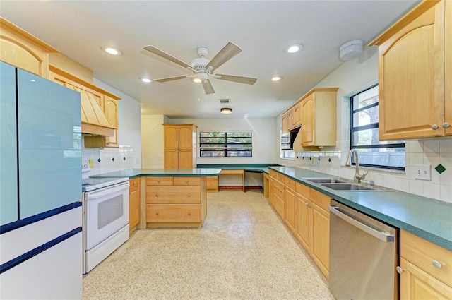 kitchen featuring tasteful backsplash, dishwasher, sink, kitchen peninsula, and electric stove