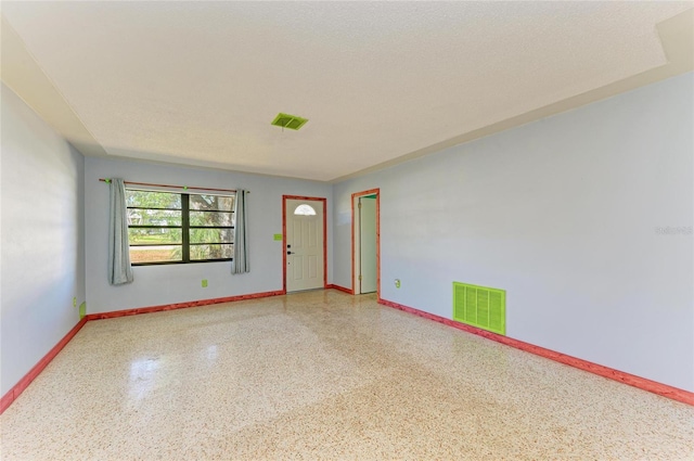 unfurnished room with a textured ceiling