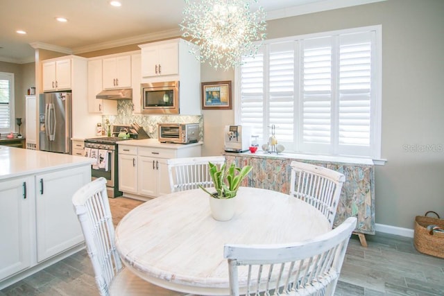 dining area featuring ornamental molding, light wood-type flooring, and a wealth of natural light