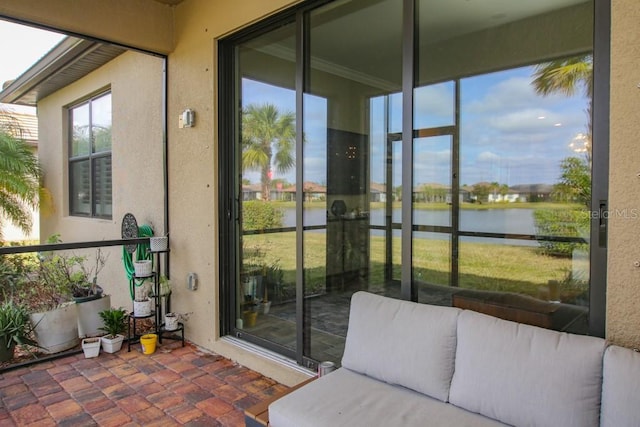 sunroom featuring a water view