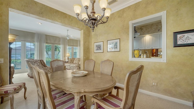 dining room with ornamental molding, ceiling fan with notable chandelier, and light carpet