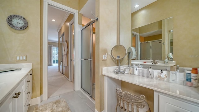 bathroom with vanity, tile patterned flooring, crown molding, and a shower with door