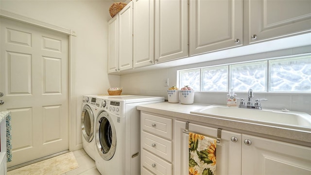 washroom featuring cabinets, washer and clothes dryer, sink, and light tile patterned floors