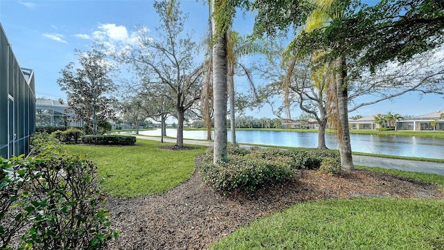 view of yard with a water view and a lanai