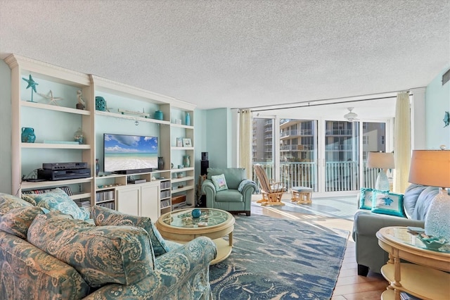 living room featuring floor to ceiling windows, a textured ceiling, and light hardwood / wood-style floors