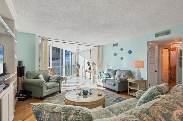 living room with expansive windows, a textured ceiling, and light hardwood / wood-style flooring