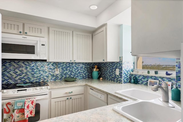 kitchen featuring tasteful backsplash, sink, and white appliances