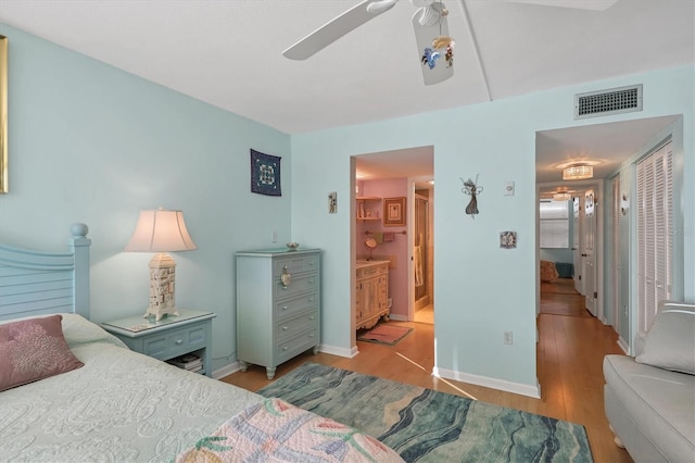 bedroom with ensuite bath, ceiling fan, and light wood-type flooring