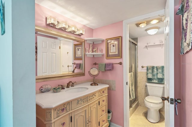 bathroom with an enclosed shower, vanity, tile patterned flooring, and toilet