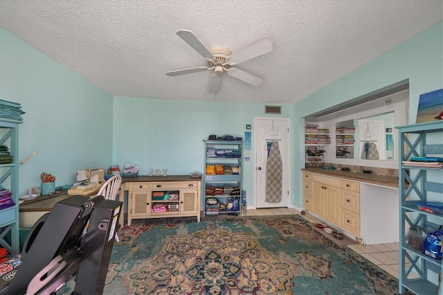 office space featuring ceiling fan, a textured ceiling, and light tile patterned floors