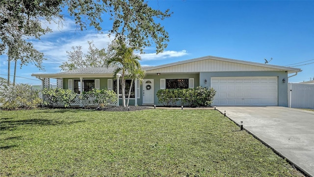 ranch-style home featuring a garage, covered porch, and a front yard