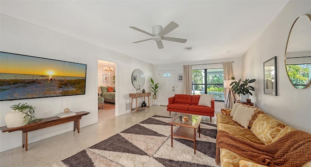 living room with ceiling fan with notable chandelier