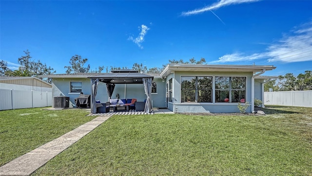 rear view of property featuring a gazebo, an outdoor hangout area, central AC, and a lawn