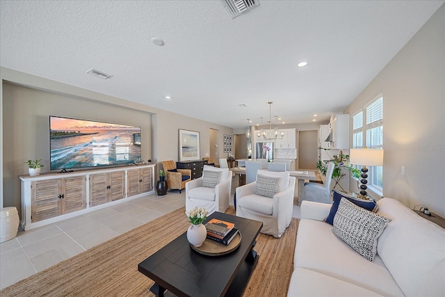 tiled living room with a chandelier and a textured ceiling