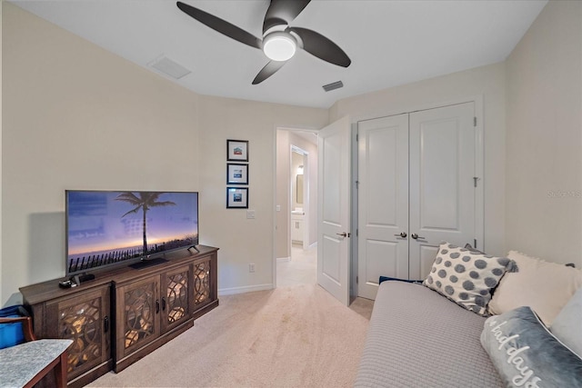 interior space with ceiling fan, light carpet, and a closet