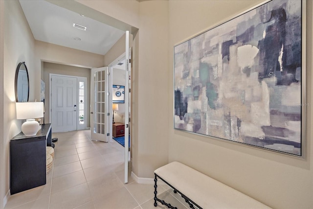 foyer with light tile patterned flooring and french doors