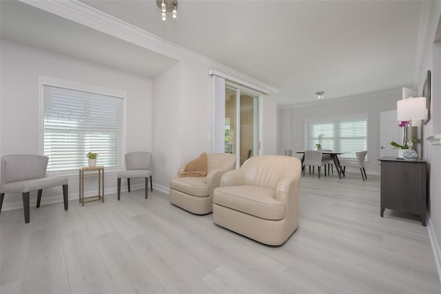 sitting room with ornamental molding, a wealth of natural light, and light hardwood / wood-style flooring