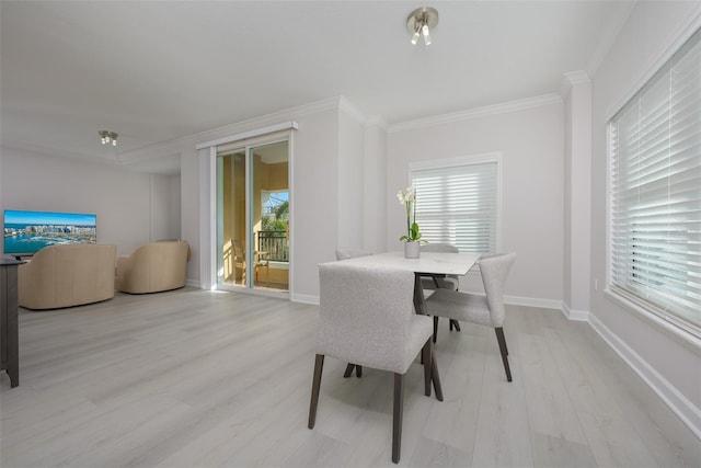 dining space with crown molding and light hardwood / wood-style floors