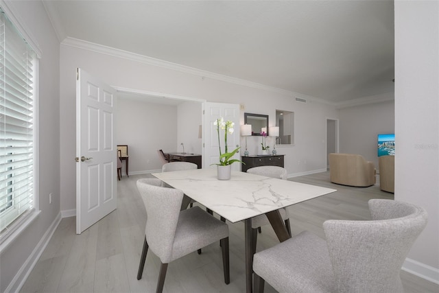 dining area featuring ornamental molding and light hardwood / wood-style floors