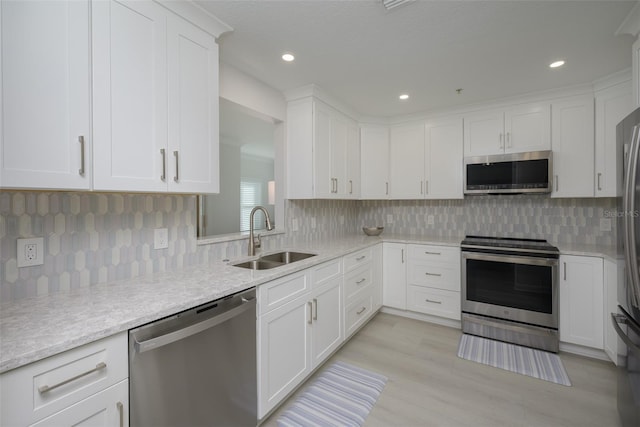 kitchen with white cabinetry, stainless steel appliances, and sink