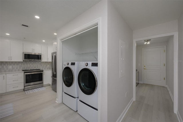 laundry area featuring washer and dryer and light wood-type flooring