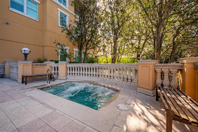 view of swimming pool featuring an in ground hot tub and a patio