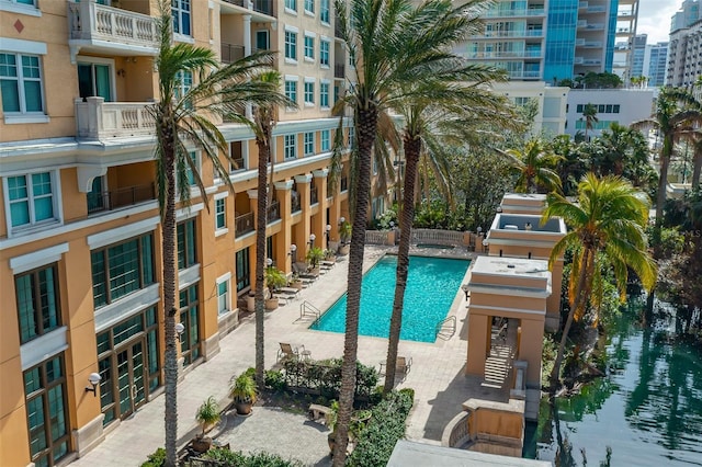 view of swimming pool with a water view and a patio