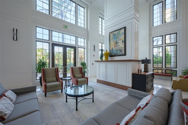 living room featuring light carpet, french doors, and a high ceiling