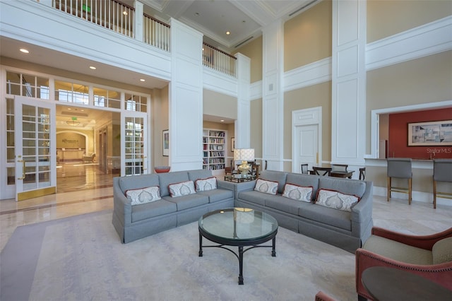 living room featuring french doors, ornamental molding, beam ceiling, decorative columns, and a high ceiling