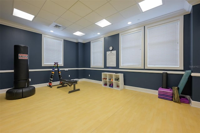 workout area with wood-type flooring and crown molding