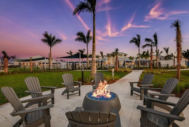 patio terrace at dusk with a yard and an outdoor fire pit